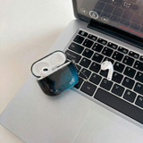Coque AirPods LUCIØLE ouverte, posée sur un clavier