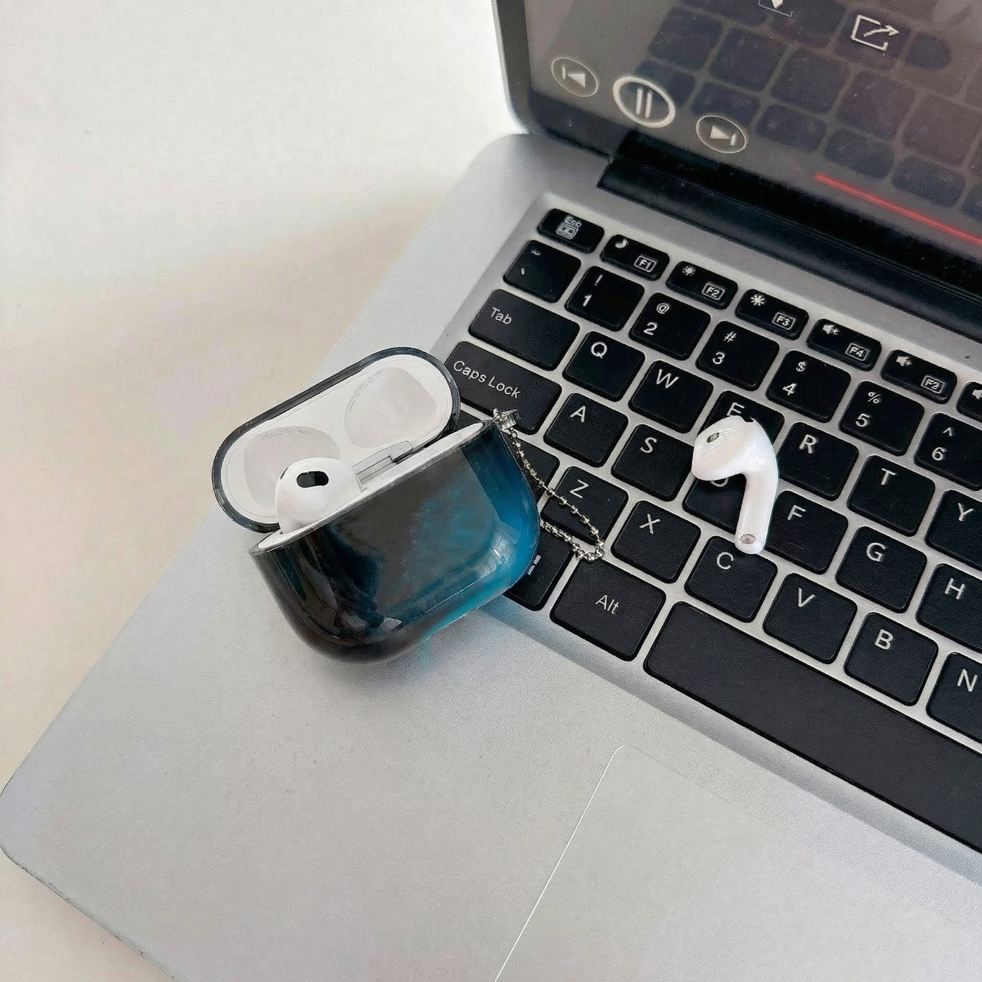 Coque AirPods LUCIØLE ouverte, posée sur un clavier